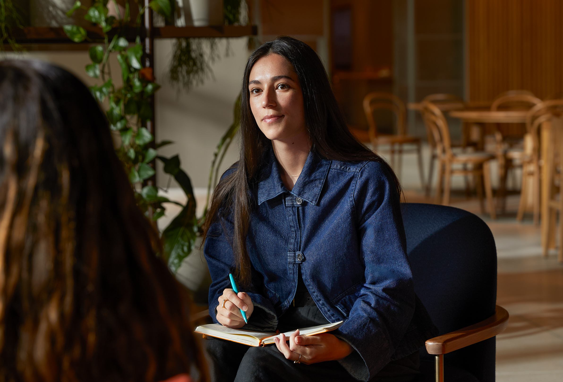 Una persona de Apple en una mesa de una zona común hablando con una compañera.
