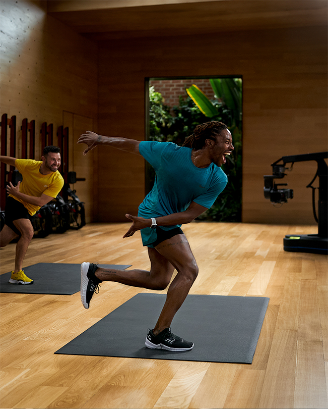 Apple Fitness+ Trainer, die ein Workout vor Kameras in einem Aufnahmestudio leiten. 