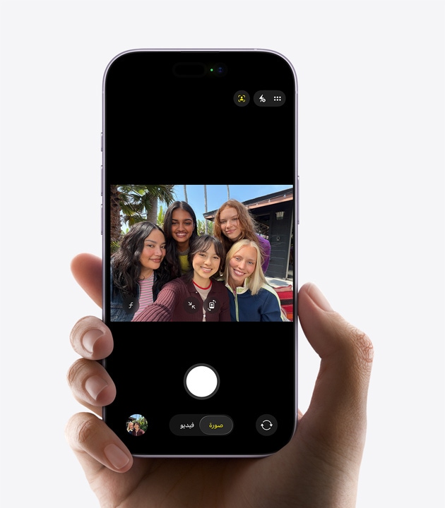 الجزء الأمامي الخارجي لجهاز iPhone، أثناء التقاط فيديو سيلفي لثلاثة أشخاص باستخدام كاميرا Center Stage الأمامية، مع مربعات صفراء تحدد الوجوه لإظهار التأطير التلقائي