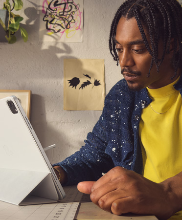 Muž v kancelářském prostředí používající stříbrný 12,9palcový iPad Pro