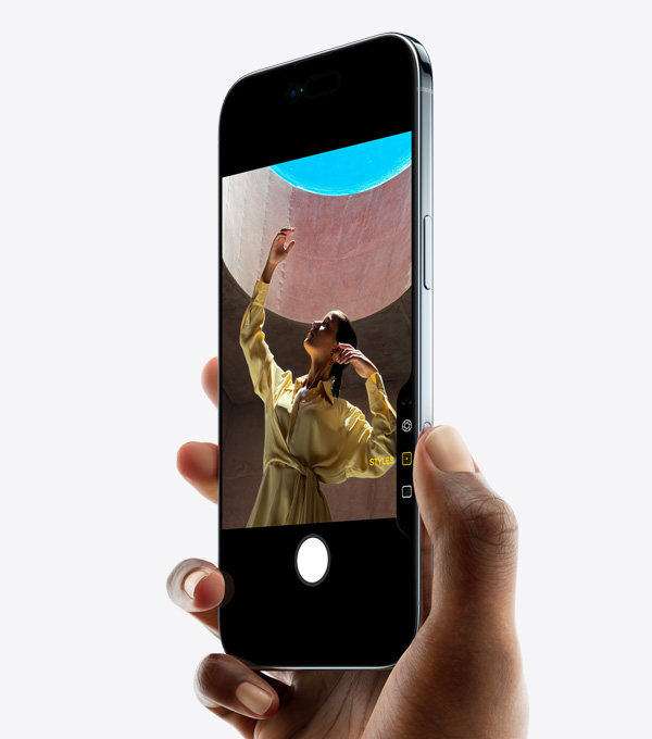 Ръка държи iPhone Air с палец върху бутона за Управление на камерата, преден екстериор, изглед отстрани, тънък профил, Dynamic Island, страничен бутон